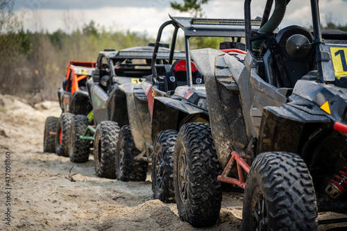 Cool quads stand in a row on sand before competition. ATV/UTV/4x4 off-road