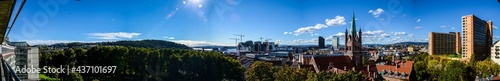 Summertime panorama of blue sky, cityscape and forest