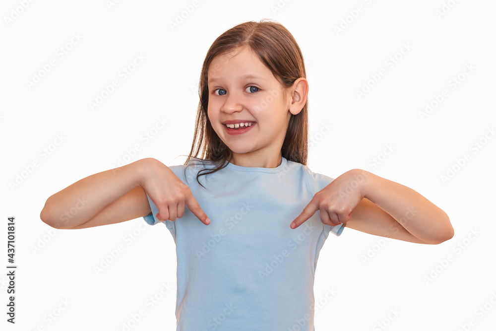 The little girl points her fingers at her chest. A smiling child points to her T-shirt The little girl points her fingers at her chest. A smiling child points to her T-shirt