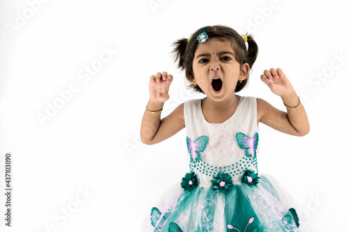 Funny indian / Asian little girl imitating tiger over white studio background. The girl holds her hands in front of her and imagines that she is a tiger, baby on a white background.
