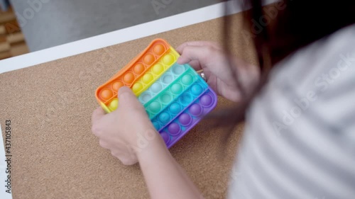 Woman plays with colored silicone antistress toy pop it