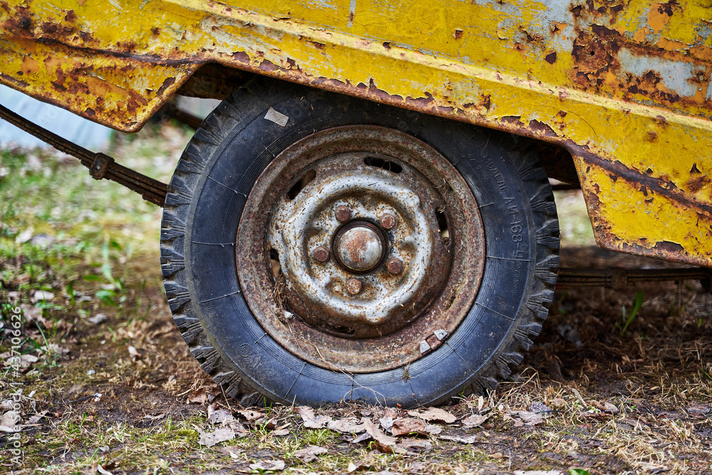 Old rusty wheel on the yellow car trailer Old rusty wheel on the yellow car trailer