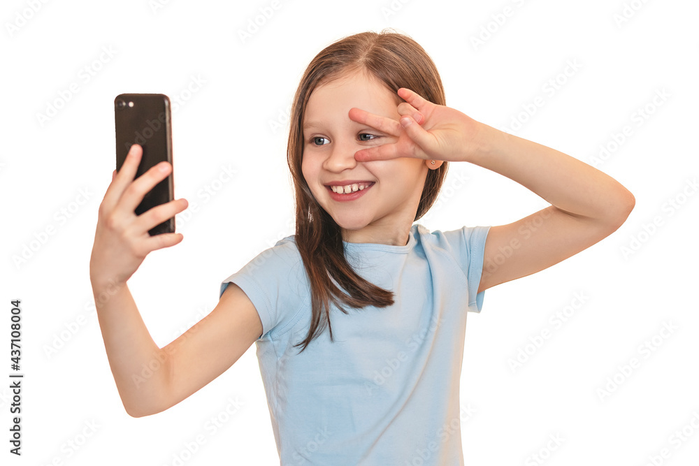 Little girl taking a selfie. The child communicates online by phone. Baby with a phone on a white background Little girl taking a selfie. The child communicates online by phone. Baby with a phone on a white background