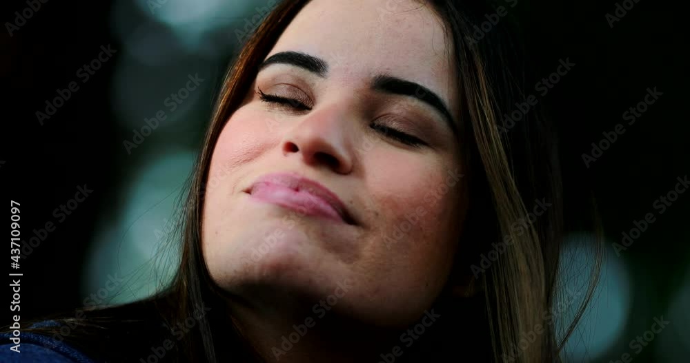 Contemplative young woman closing eyes and opening looking at sky smiling Contemplative young woman closing eyes and opening looking at sky smiling
