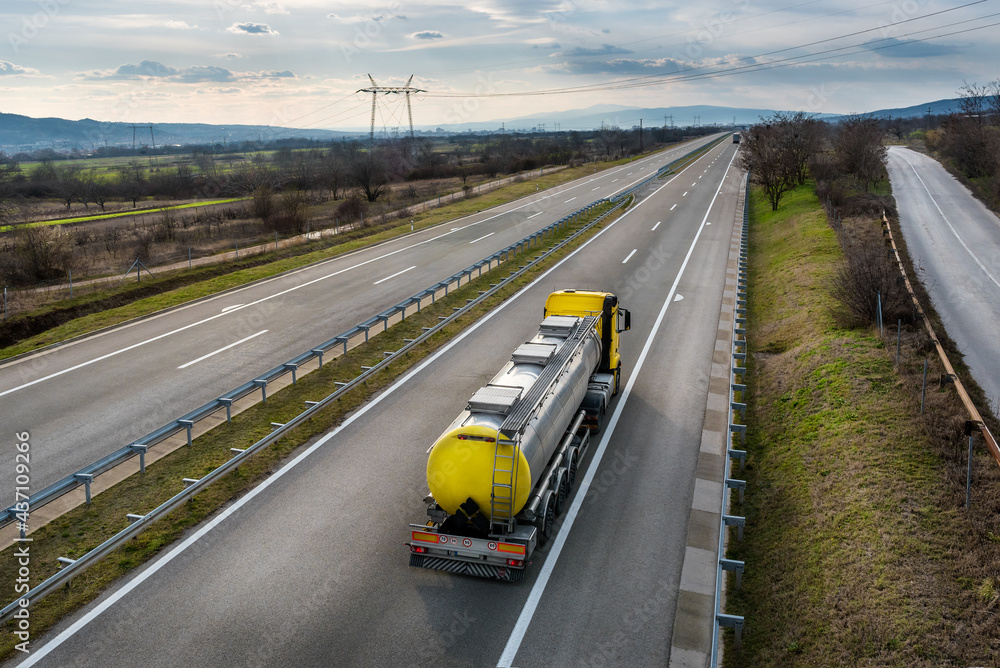 Isothermal Tank truck driving on highway. Oil and Gas Transportation and Logistics. Metal chrome cistern tanker with petrochemicals products. Liquid Chemical Freight