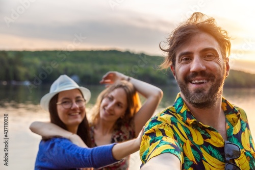 Group of happy young adults having fun during beach party. Best friends taking selfie together on holiday. Concept about vacation, people, holiday and friendship.