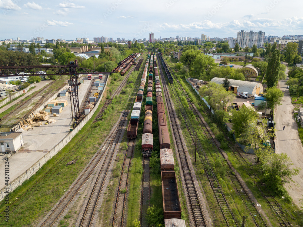 Freight trains on railway tracks. Aerial drone view. Sunny spring day.