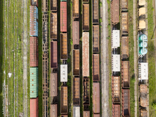 Freight trains on railway tracks. Aerial drone top view. Sunny spring day.