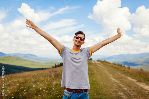 Happy man hiker raising arms feeling happy. Traveling in summer Ukraine. Trip to Carpathian mountains.