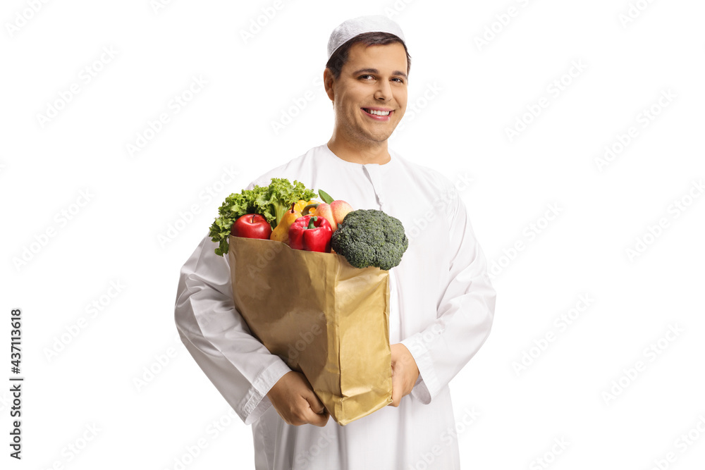 Young muslim man holding a shopping bag with groceries Young muslim man holding a shopping bag with groceries