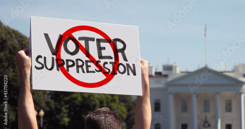 Fényképezés WASHINGTON, DC - Circa March, 2021 - A man waves a handmade STOP VOTER SUPPRESSION protest sign outside the White House