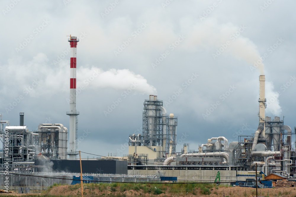 Factory chimneys against the gray autumn sky. Utopian landscape background. White toxic smoke is coming from a huge pipe. Pollution of the environment and nature. The collapse of civilization. Factory chimneys against the gray autumn sky. Utopian landscape background. White toxic smoke is coming from a huge pipe. Pollution of the environment and nature. The collapse of civilization.