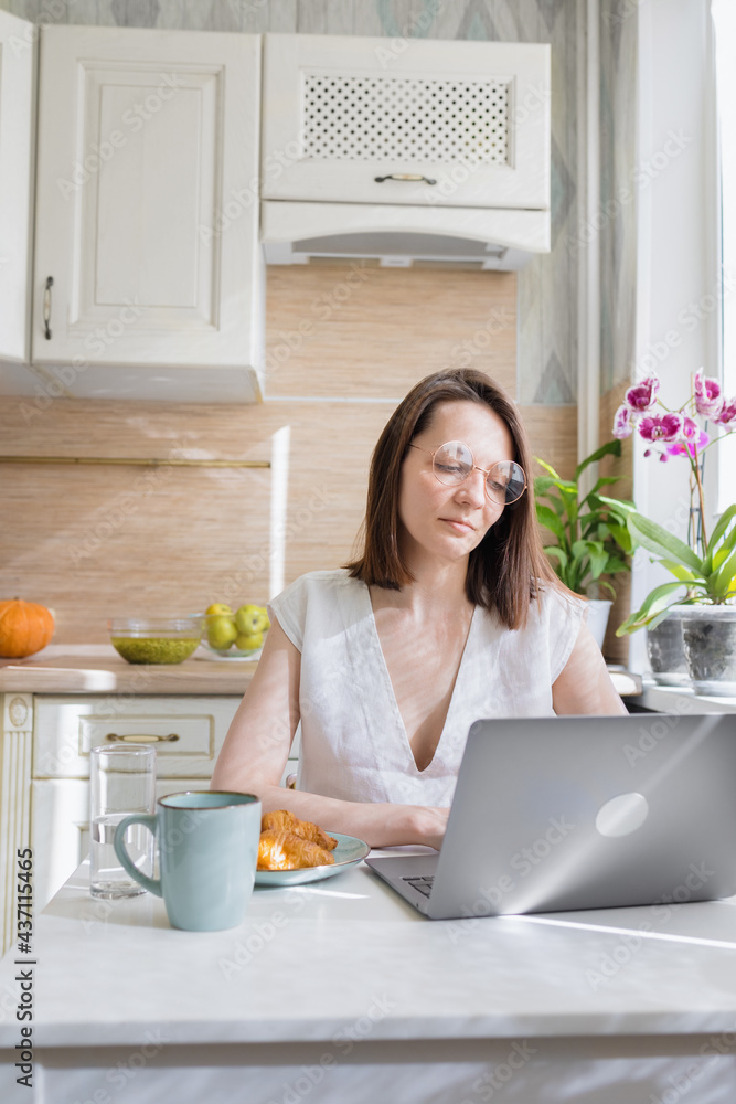 European woman in her home office working with her laptop and drinking coffee, coffee in the morning, European woman brewing coffee and drinking it, croissants and coffee for breakfast, internet European woman in her home office working with her laptop and drinking coffee, coffee in the morning, European woman brewing coffee and drinking it, croissants and coffee for breakfast, internet