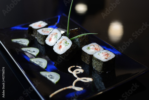 Japanese sushi on a black plate.