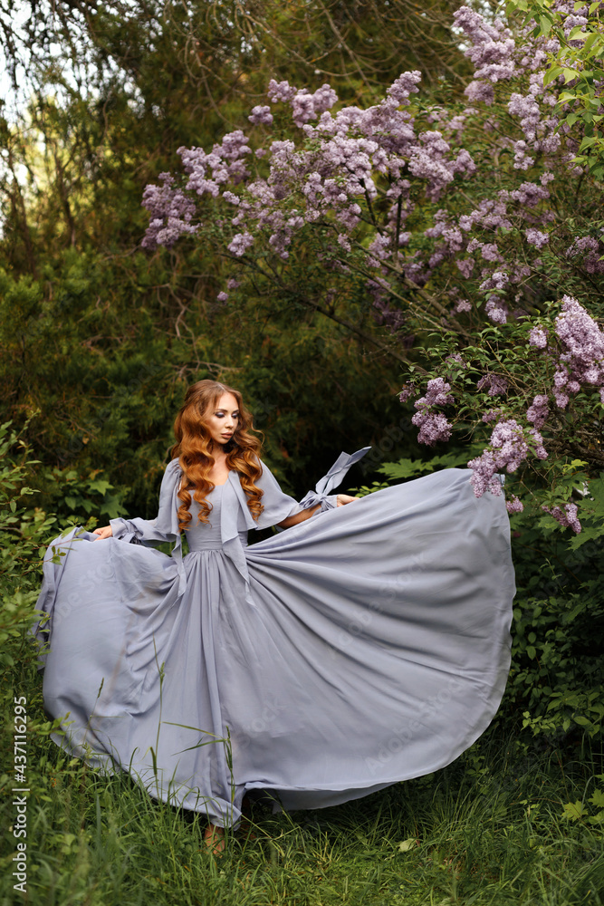 Girl in long dress near lilac on green summer background Girl in long dress near lilac on green summer background