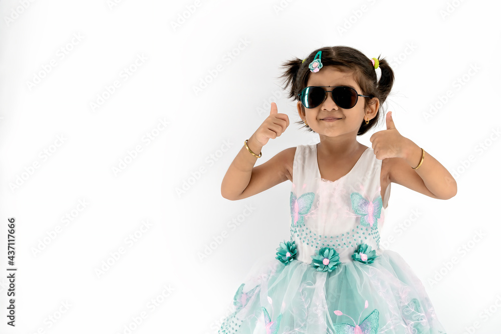 Portrait of little cute asian girl wearing dark sun glass with her thump up, advertisement concept, little asian teenage thumps up with white background and empty space at left, Studio Shot Portrait of little cute asian girl wearing dark sun glass with her thump up, advertisement concept, little asian teenage thumps up with white background and empty space at left, Studio Shot
