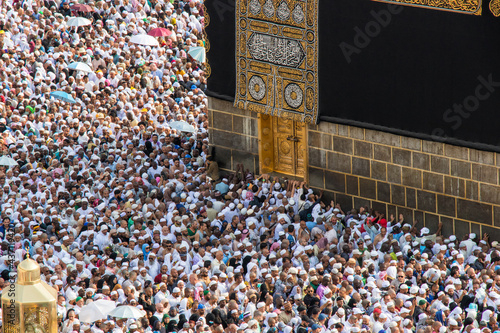 Holy Kaaba in Mecca city. Door of Kaaba - Multazam. Crowd of muslim pilgrims circumambulate (tawaf) photo