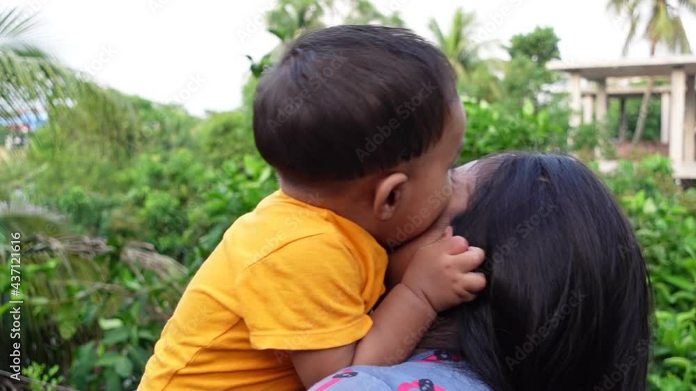 Close up of happy young south Asian mother hugging cuddling little infant. A toddler and mom love smiling. Small baby enjoying the tender family moment. Motherhood and child care concept. Close up of happy young south Asian mother hugging cuddling little infant. A toddler and mom love smiling. Small baby enjoying the tender family moment. Motherhood and child care concept.