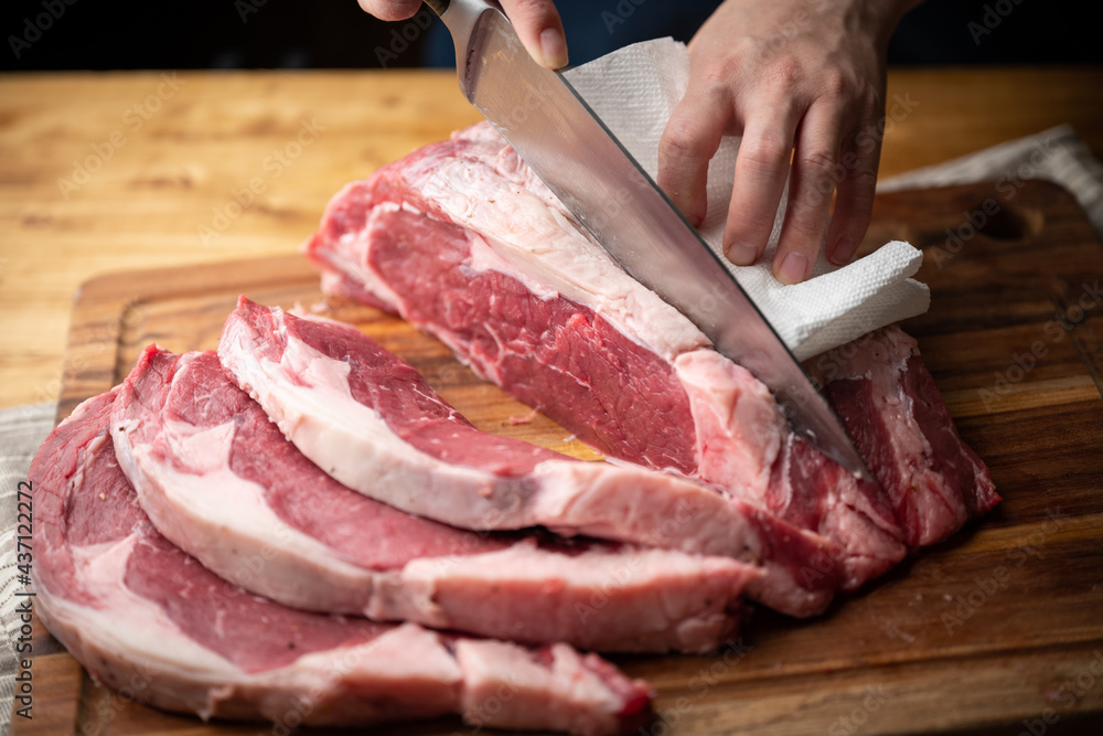 chef cutting block of ribeye beef steak