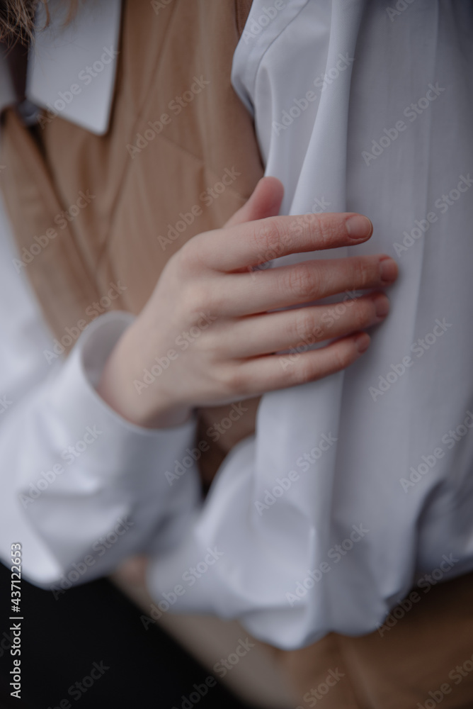 Woman in white shirt cross the hands. Woman hands close up.