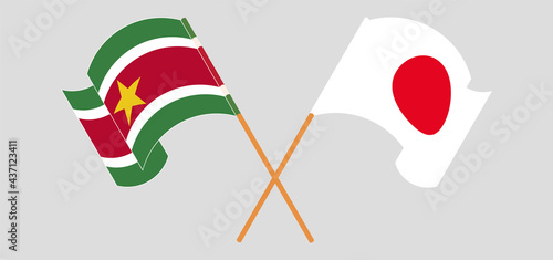 Crossed and waving flags of Suriname and Japan