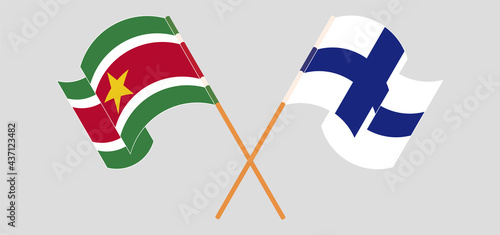 Crossed and waving flags of Suriname and Finland
