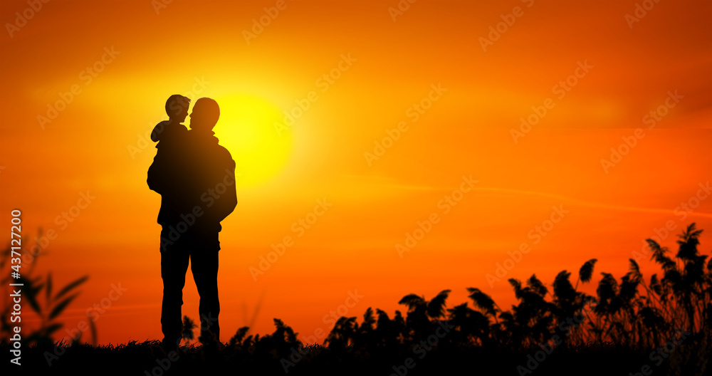 Father holding his son at sunset. Father son relationship concept.