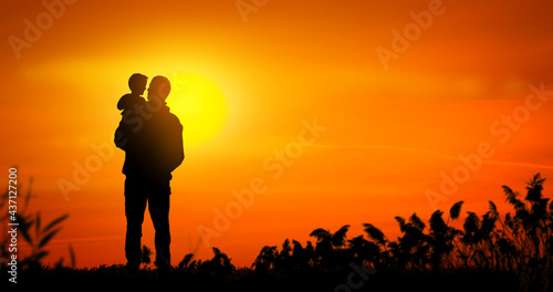 Father holding his son at sunset. Father son relationship concept.