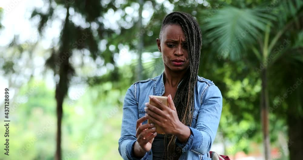 African woman reacting with shock and surprise to cellphone message African woman reacting with shock and surprise to cellphone message