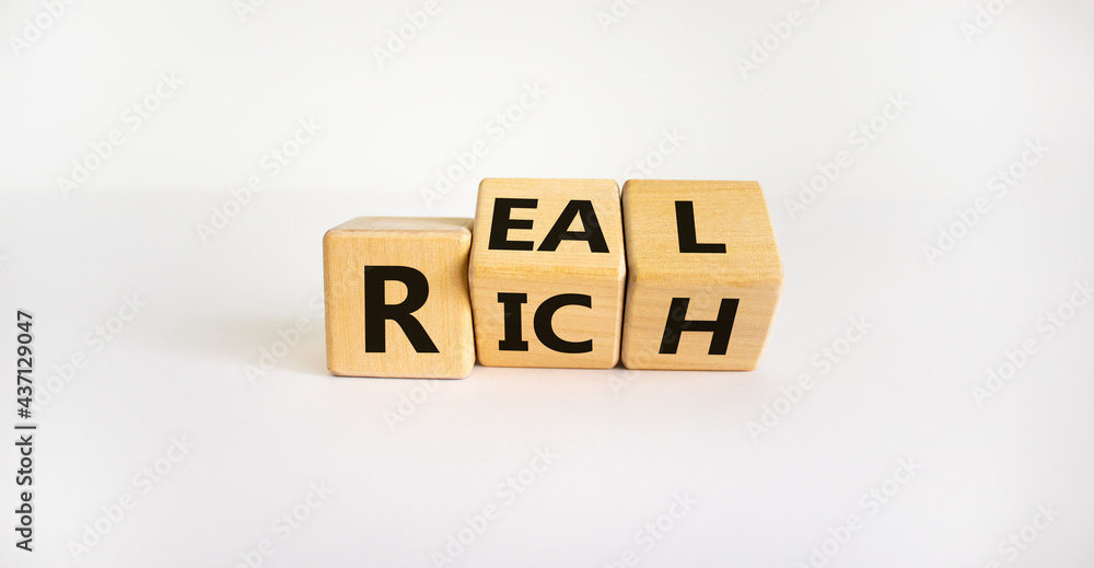 Real rich symbol. Turned wooden cubes with words 'Real rich'. Beautiful white background. Real rich and business concept. Copy space. Real rich symbol. Turned wooden cubes with words 'Real rich'. Beautiful white background. Real rich and business concept. Copy space.