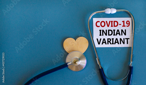 Covid-19 indian variant strain symbol. White card with words 'Covid-19 indian variant', stethoscope on blue background. Wooden heart. Medical, covid-19 indian variant strain concept, copy space.