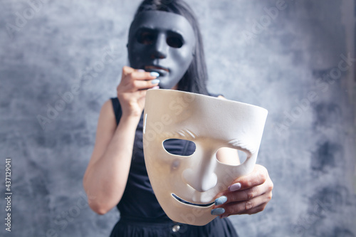 woman trying on white and black plastic mask photo