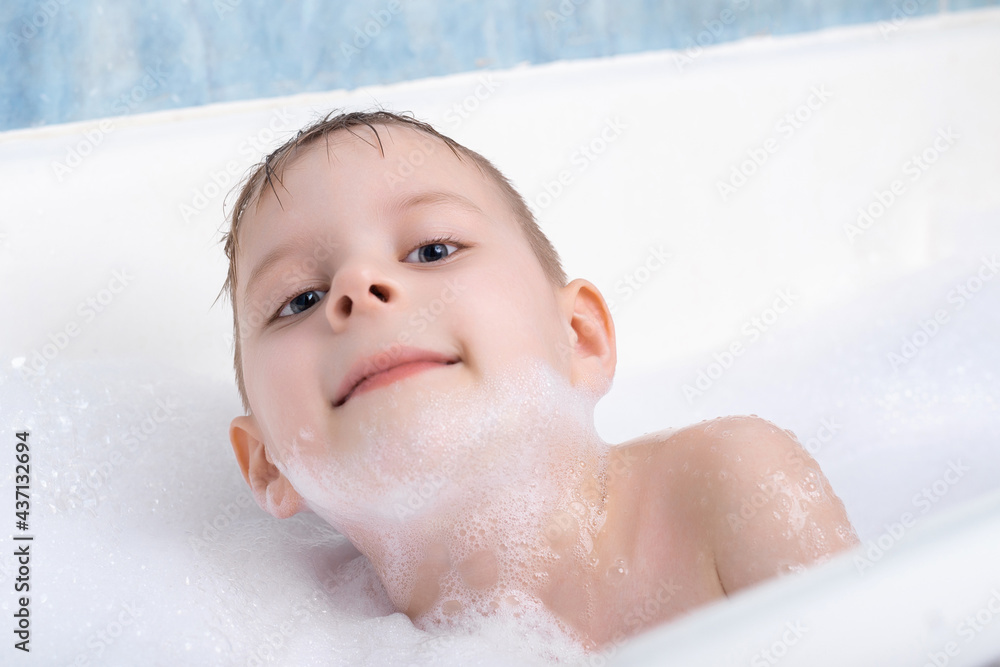 A young boy takes a bath with foam. Personal hygiene for children. A young boy takes a bath with foam. Personal hygiene for children.