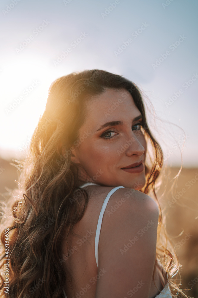 Retrato cercano de una chica joven guapa en un campo de trigo al atardecer Retrato cercano de una chica joven guapa en un campo de trigo al atardecer