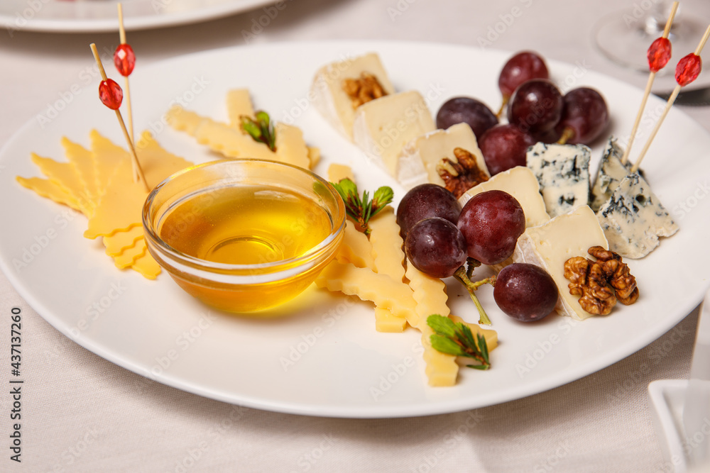 Cheese plate with grape and honey.