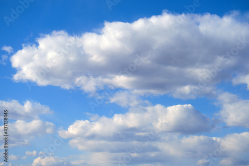 Blue sky background with fluffy soft clouds on a summer day