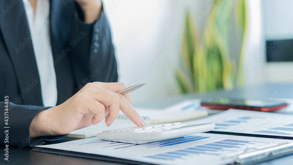 Business people doing business in finance and calculating, analyzing, graphing on costs of investments, real estate and more, tax system on the desk with laptops and calculators with documents Business people doing business in finance and calculating, analyzing, graphing on costs of investments, real estate and more, tax system on the desk with laptops and calculators with documents