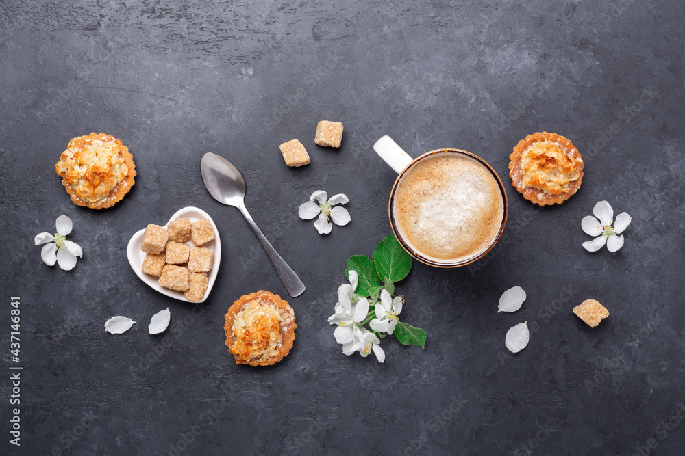 Coffee, sweets and spring flowers on dark stone background. Top view Coffee, sweets and spring flowers on dark stone background. Top view