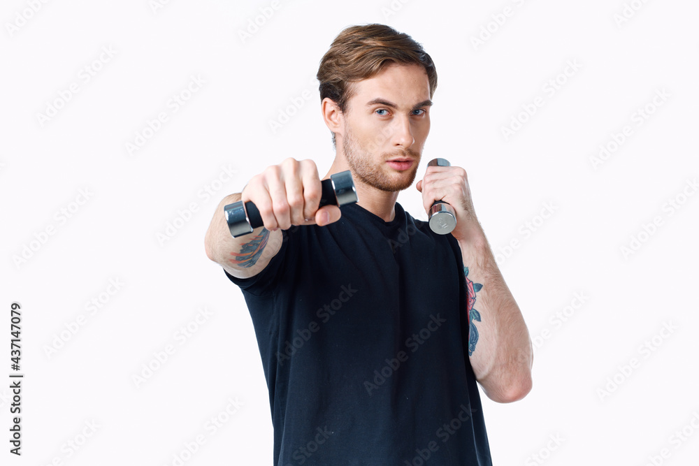 guy in a black T-shirt with dumbbells in his hand on a white background Copy Space guy in a black T-shirt with dumbbells in his hand on a white background Copy Space