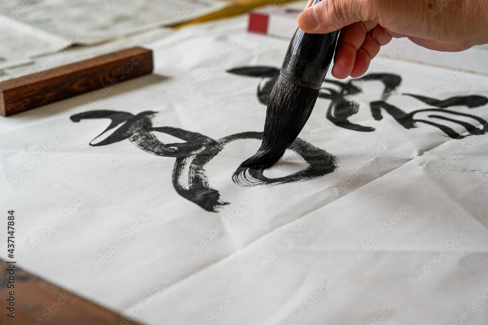 A calligrapher is writing calligraphy characters with a large brush, a close-up of the brush. Translation: The heights are too cold - obrazy, fototapety, plakaty 
