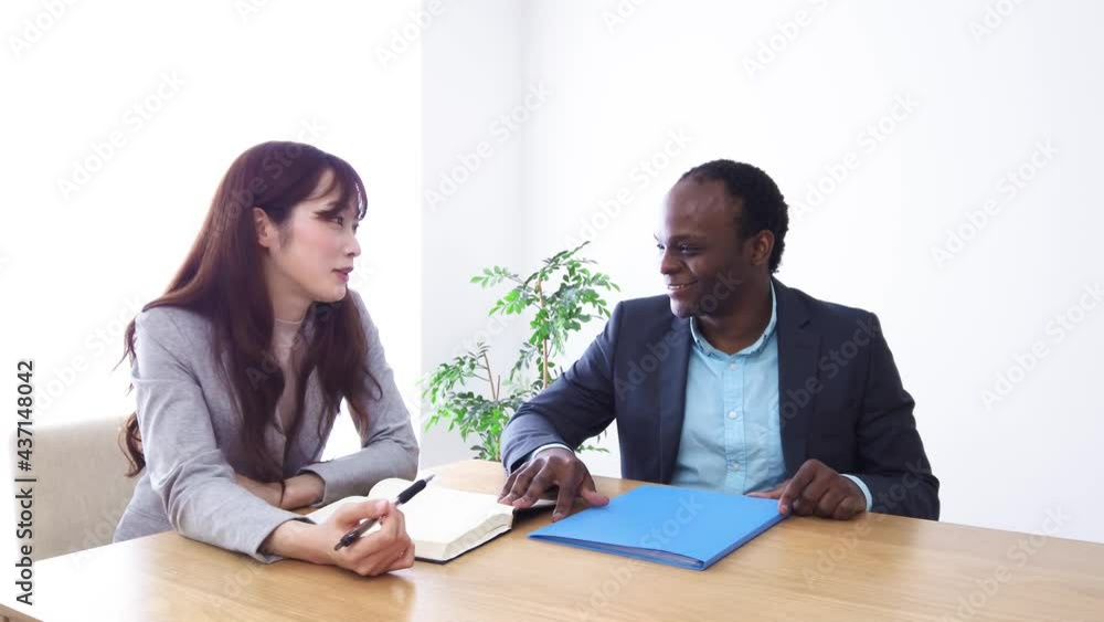 オフィスで会話をするビジネスパーソン