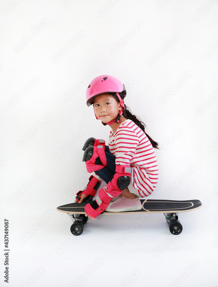 Portrait of Asian kid skating on a skateboard isolated on white background. Kid riding on skateboard Portrait of Asian kid skating on a skateboard isolated on white background. Kid riding on skateboard