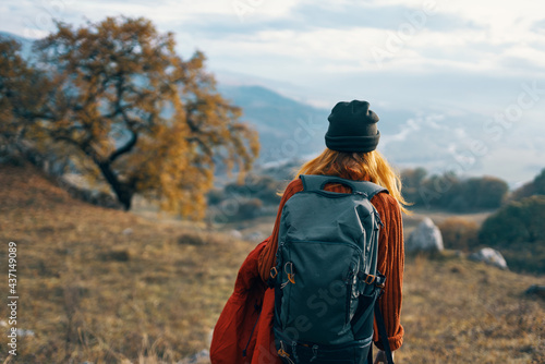cheerful woman creates a backpack on a trip walk landscape