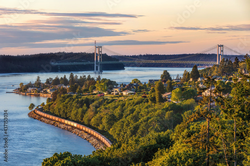 Tacoma Narrows Bridge taken from the south with a train headed north during a sunset