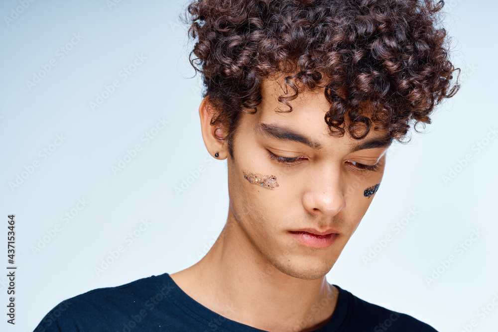 Cheerful man with curly hair cosmetics on face clean skin Cheerful man with curly hair cosmetics on face clean skin