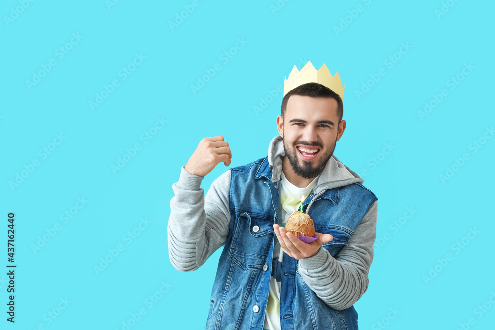 Happy young man with birthday cupcake on color background Happy young man with birthday cupcake on color background