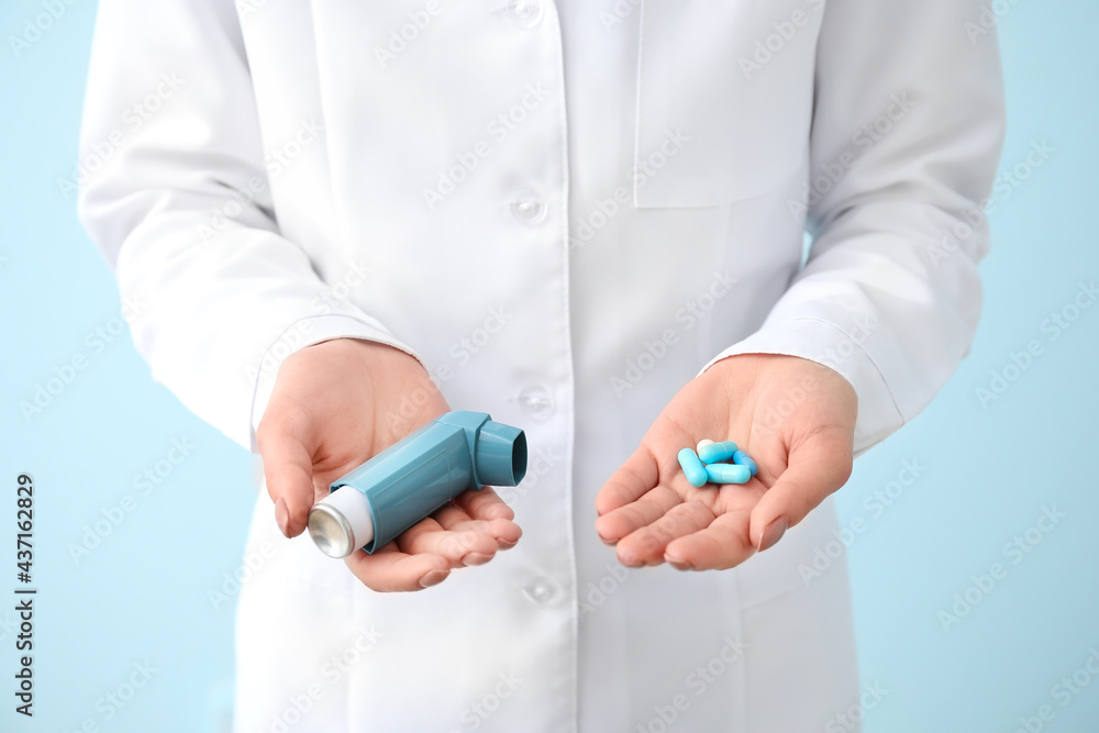 Female allergist with inhaler and pills on color background Female allergist with inhaler and pills on color background