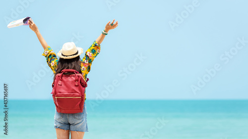 Happy traveler and tourism women travel summer on the beach.  Asia people holding map and raise arm planning travel trip and relax outdoor for destination and leisure