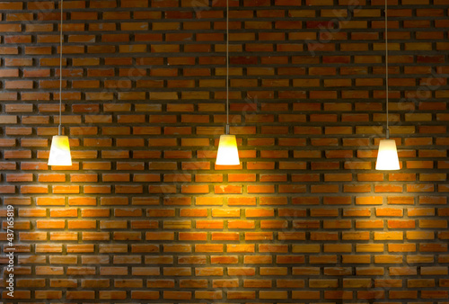Brick wall illuminated by three lighting equipments
