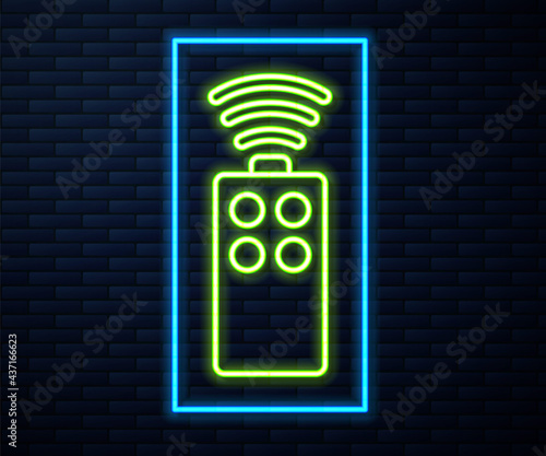Glowing neon line Remote control for the camera icon isolated on brick wall background. An auxiliary device that allows you to work with a camera from a distance. Vector